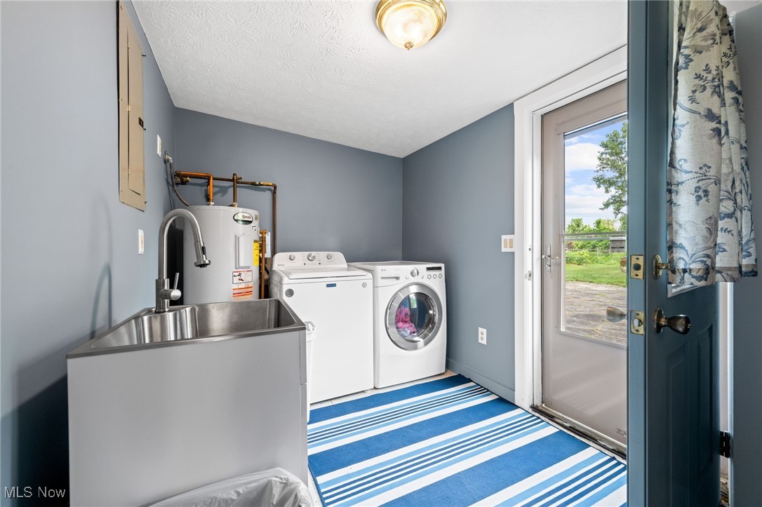 3945 Columbia Road Medina, OH 44256 - Photo 9 of 40 Laundry room featuring independent washer and dryer, water heater, and a textured ceiling