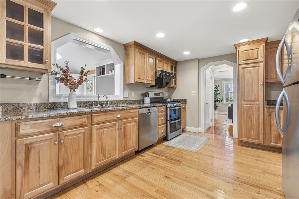 85 Blake Road Lexington, MA 02420 - Photo 8 of 42 a kitchen with stainless steel appliances granite countertop a refrigerator a sink dishwasher a stove and white countertops with wooden floor