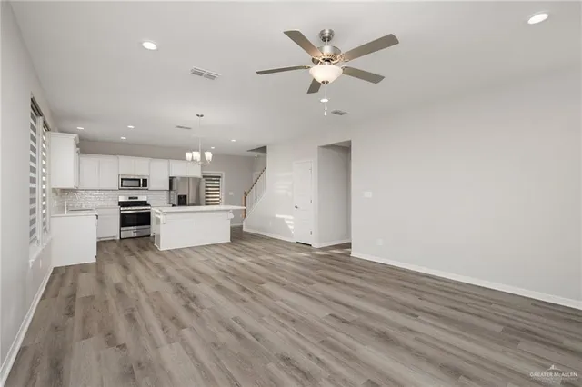 a view of a kitchen with microwave and white cabinets