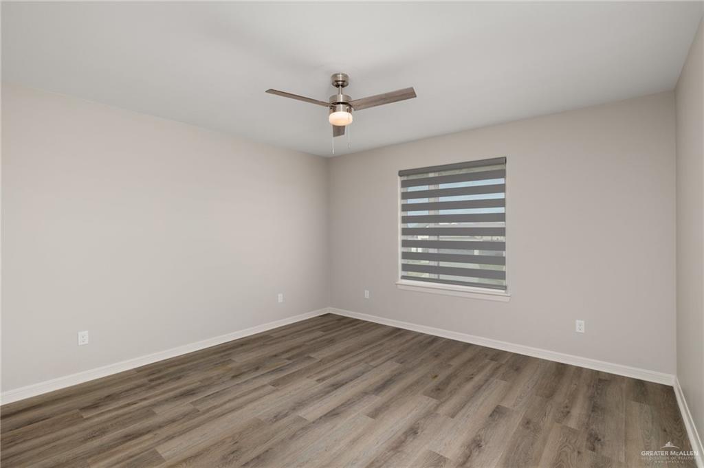 14325 Chalk Rdg Drive McAllen, TX 78504 - Photo 7 of 17 an empty room with wooden floor ceiling fan and window