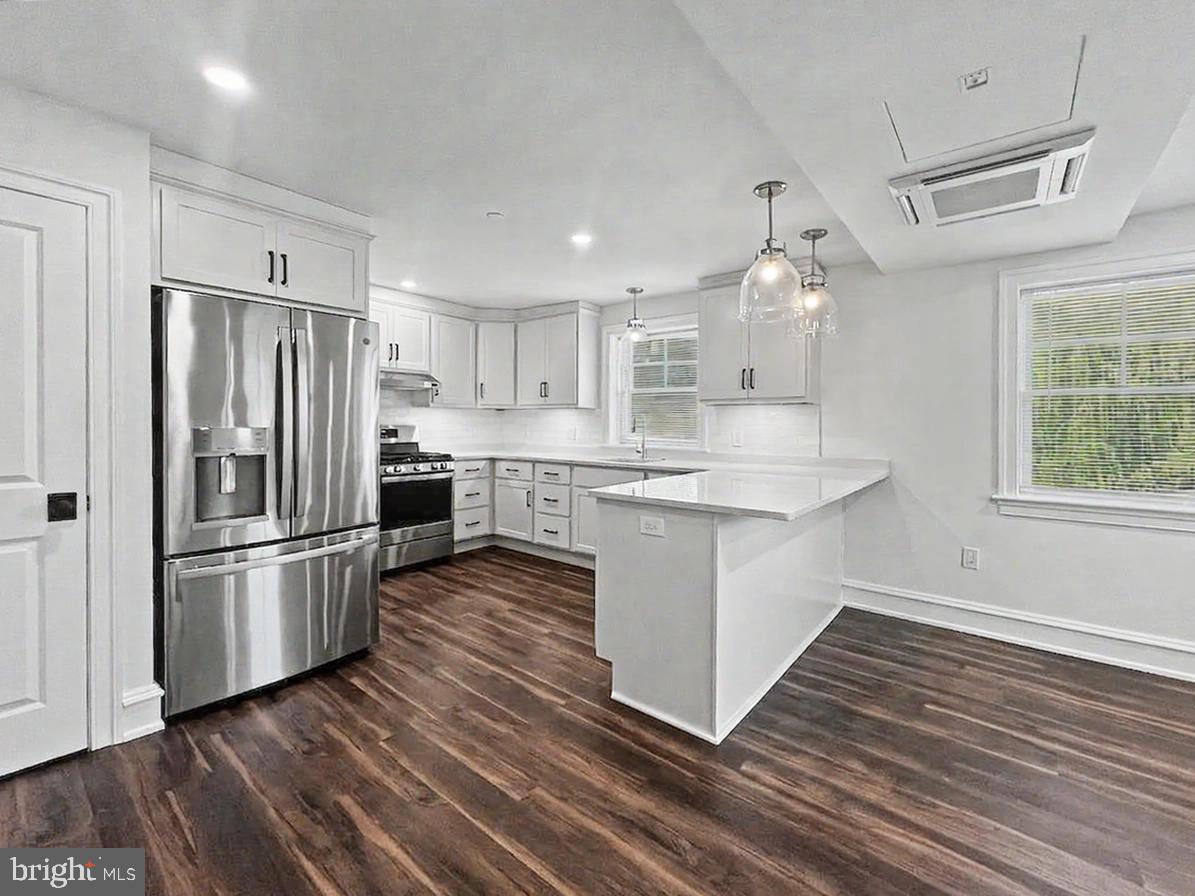 1 Pennsylvania Avenue, Unit 1 Wayne, PA 19087 - Photo 6 of 22 a kitchen with stainless steel appliances wooden floor sink and refrigerator
