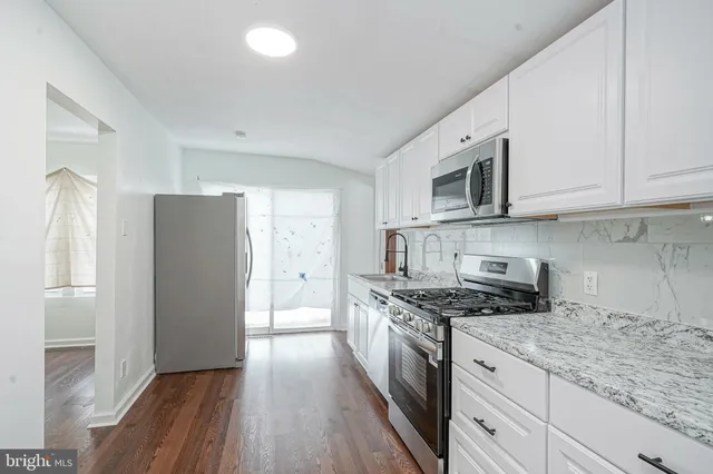 a kitchen with stainless steel appliances granite countertop a stove a refrigerator and a microwave