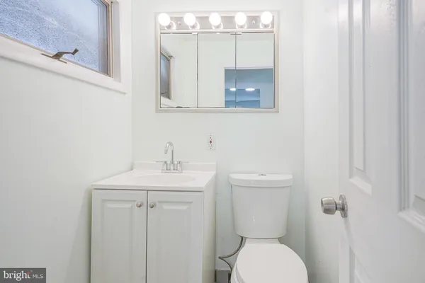 a bathroom with a toilet a sink and mirror