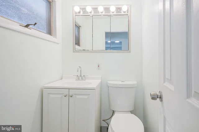 a bathroom with a toilet a sink and mirror