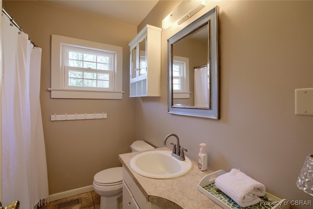 10371 Buckley Hall Road Mathews, VA 23109 - Photo 18 of 28 Full bath with visible vents, baseboards, toilet, tile patterned floors, and vanity