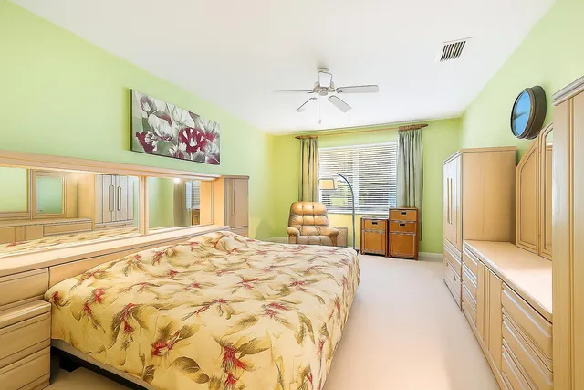 a bedroom with a bed dresser and a large window