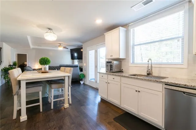 a kitchen with granite countertop a sink and wooden floor