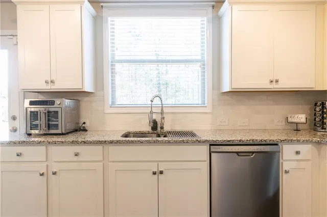 a kitchen with granite countertop cabinets and window