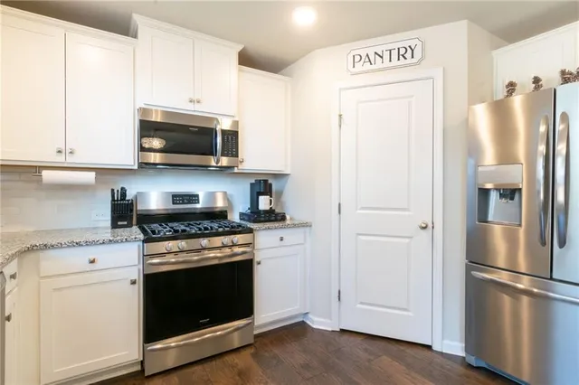 a kitchen with stainless steel appliances a refrigerator stove and microwave