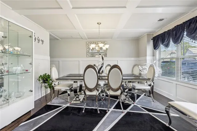 a view of a dining room with furniture a chandelier and wooden floor