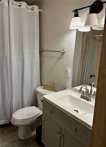 a bathroom with a sink a toilet and shower curtain