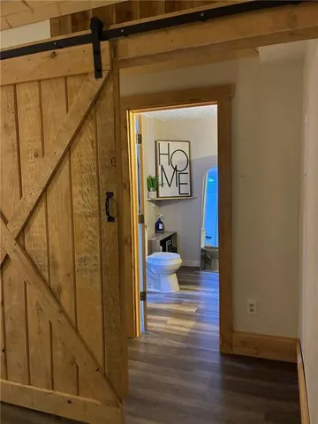 a view of a hallway with wooden floor and stairs