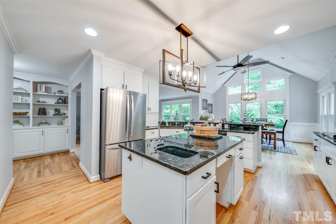 12608 Old Creedmoor Road Raleigh, NC 27613 - Photo 2 of 30 a kitchen with stainless steel appliances granite countertop a refrigerator a sink dishwasher a stove and a dining table with wooden floor