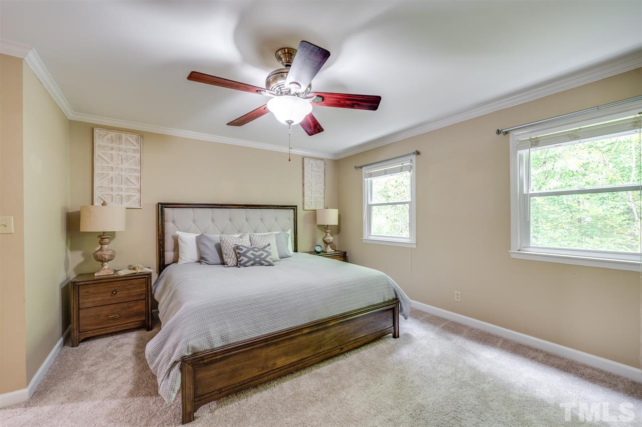 12608 Old Creedmoor Road Raleigh, NC 27613 - Photo 14 of 30 a bedroom with a large bed and a chandelier