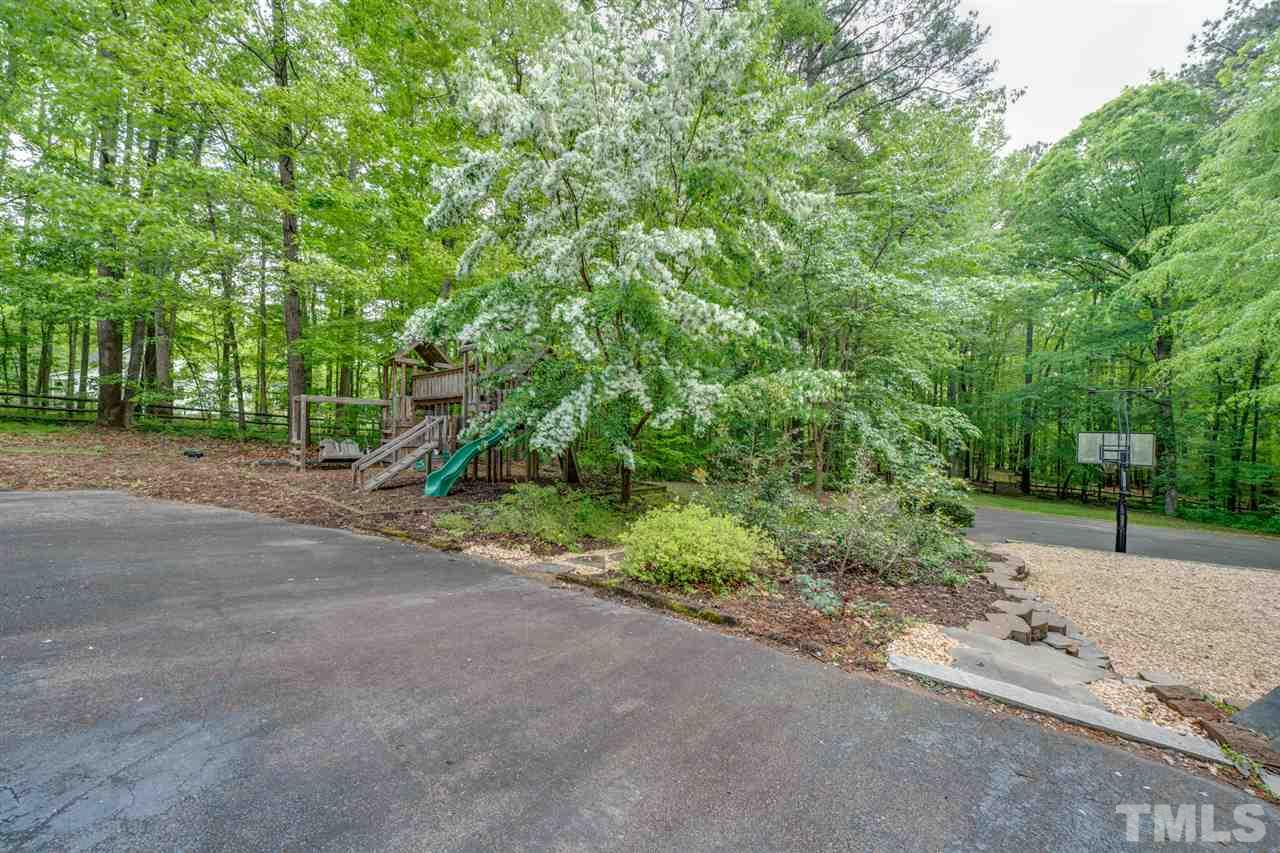 12608 Old Creedmoor Road Raleigh, NC 27613 - Photo 28 of 30 a view of a road with plants and trees in the background