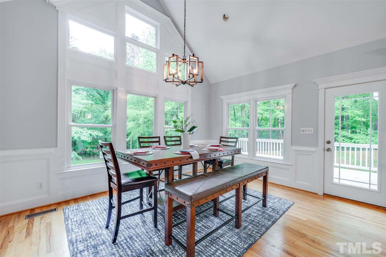 12608 Old Creedmoor Road Raleigh, NC 27613 - Photo 7 of 30 a view of a dining room with furniture wooden floor and a chandelier