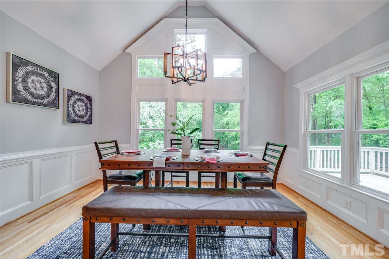 12608 Old Creedmoor Road Raleigh, NC 27613 - Photo 8 of 30 a view of a dining room with furniture a chandelier and wooden floor