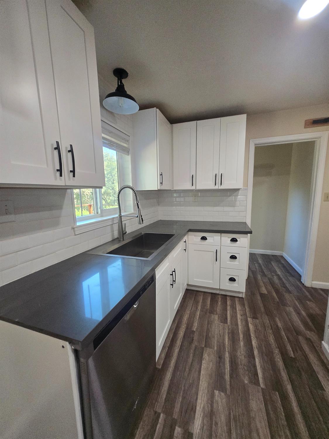 10601 Lime Kiln Road Grass Valley, CA 95949 - Photo 17 of 79 Kitchen featuring white shaker cabinetry with matte black hardware, dark solid surface countertops, and wood-finish flooring