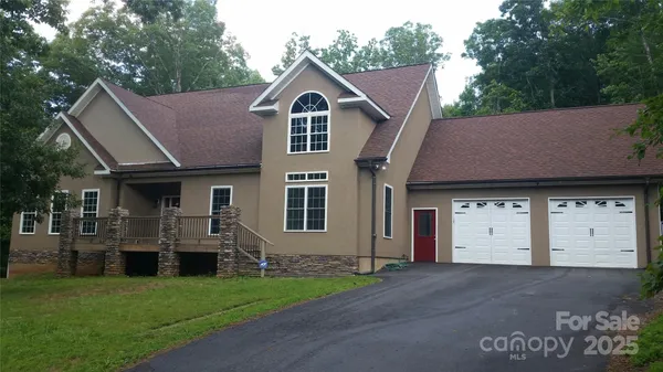 a view of a big house with a big yard and large trees
