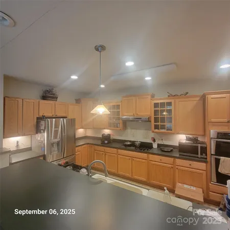 a kitchen with stainless steel appliances granite countertop a refrigerator a sink and a stove