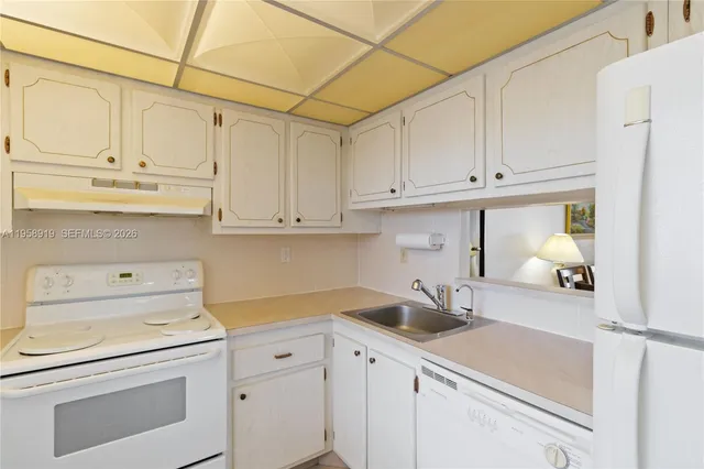 a kitchen with white cabinets and white appliances