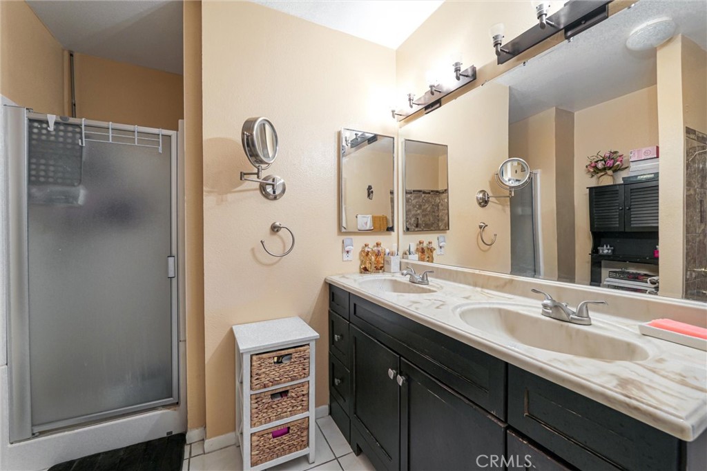 19545 Sherman Way, Unit 97 Reseda, CA 91335 - Photo 15 of 26 a bathroom with a granite countertop sink a mirror and a shower