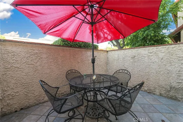 a patio with a table and chairs under an umbrella