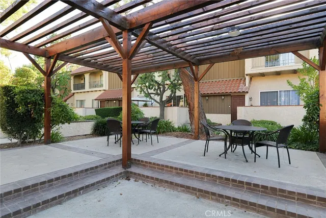 a view of a patio with table and chairs potted plants and a palm tree