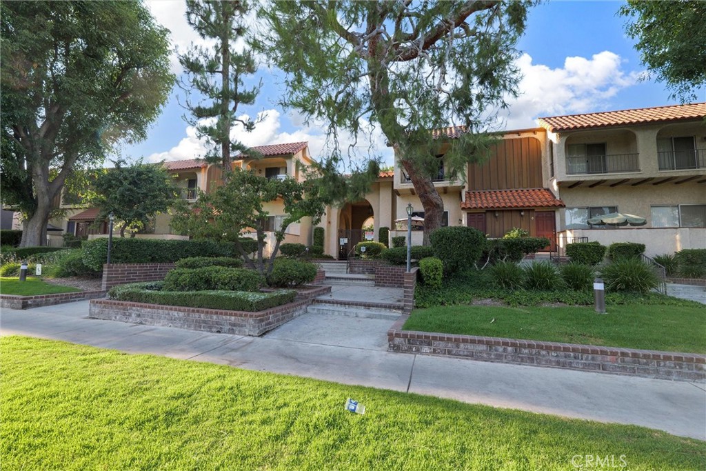 19545 Sherman Way, Unit 97 Reseda, CA 91335 - Photo 26 of 26 a front view of a house with a yard and a garden