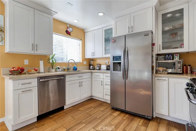 a kitchen with a refrigerator a sink and cabinets