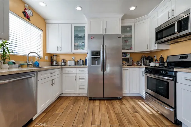 a kitchen with granite countertop stainless steel appliances a sink cabinets and a window
