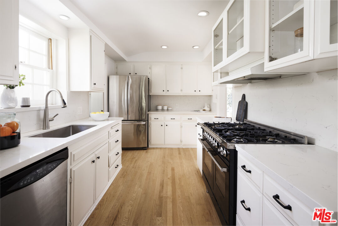 10613 Rochester Avenue Los Angeles, CA 90024 - Photo 16 of 27 a kitchen with stainless steel appliances a sink stove and cabinets