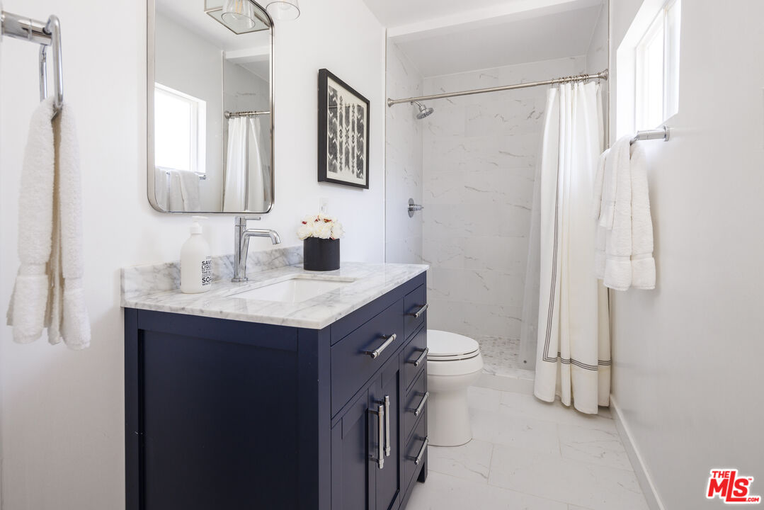 10613 Rochester Avenue Los Angeles, CA 90024 - Photo 18 of 27 a bathroom with a double vanity sink toilet and shower