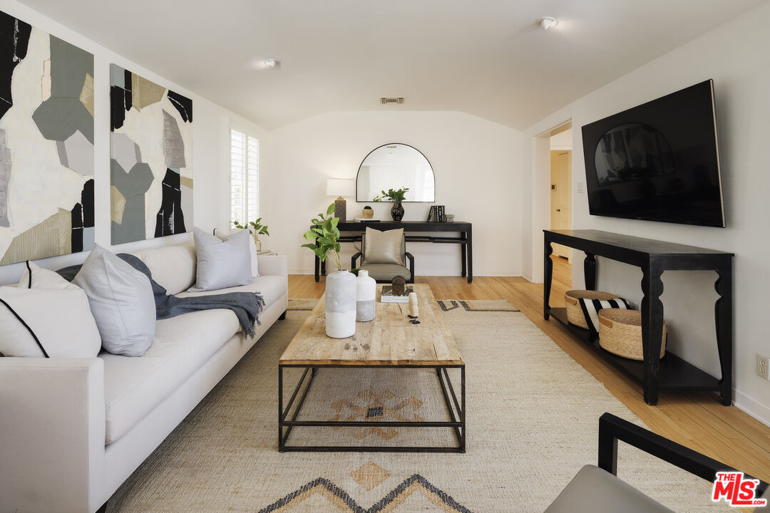 10613 Rochester Avenue Los Angeles, CA 90024 - Photo 2 of 27 a living room with furniture a flat screen tv and a floor to ceiling window