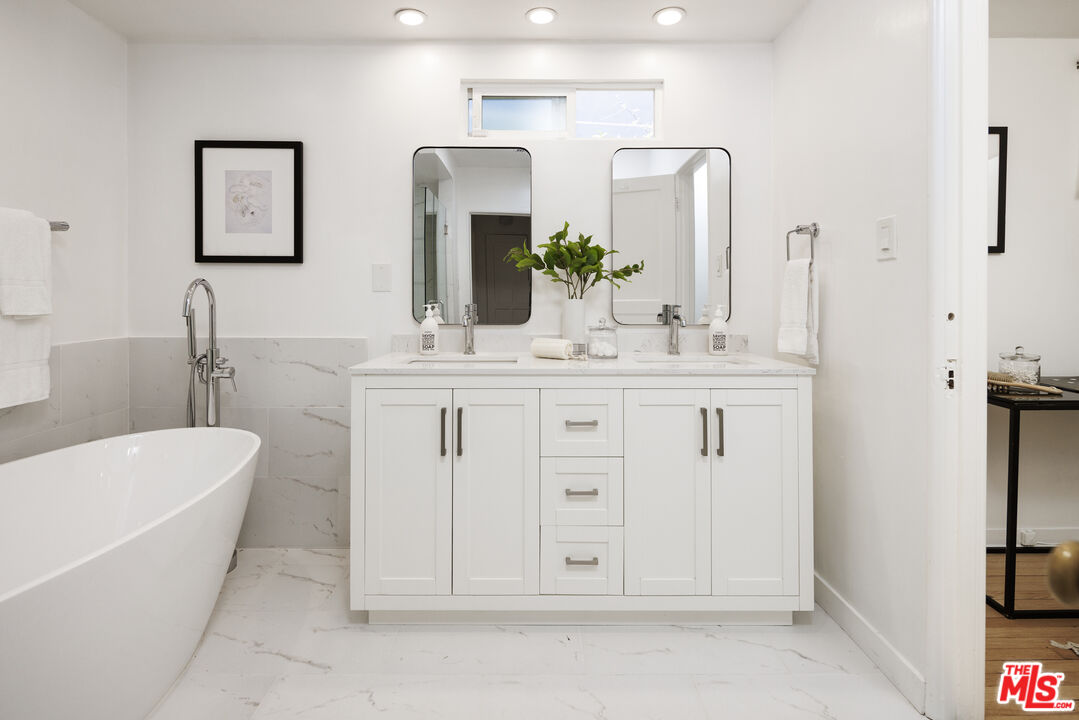 10613 Rochester Avenue Los Angeles, CA 90024 - Photo 21 of 27 a spacious bathroom with a double vanity sink a mirror and a bathtub