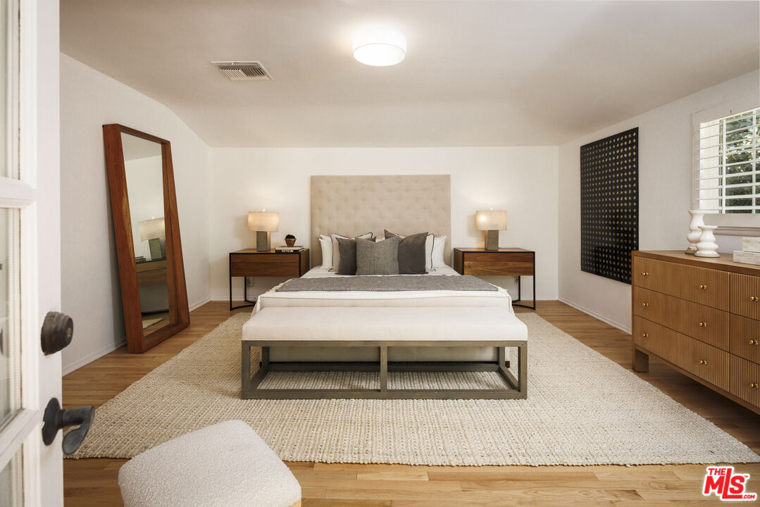 10613 Rochester Avenue Los Angeles, CA 90024 - Photo 23 of 27 a bedroom with a bed and wooden floor