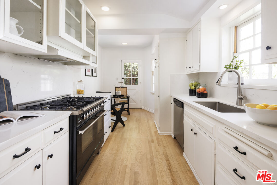 10613 Rochester Avenue Los Angeles, CA 90024 - Photo 4 of 27 a kitchen with stainless steel appliances a stove a sink dishwasher and cabinets with wooden floor