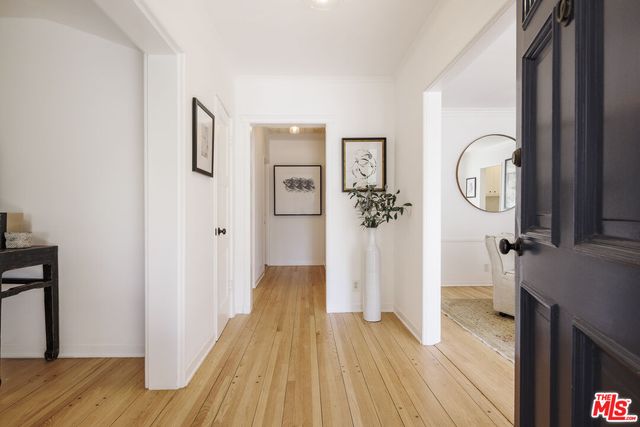 a view of a livingroom with wooden floor and a bathroom