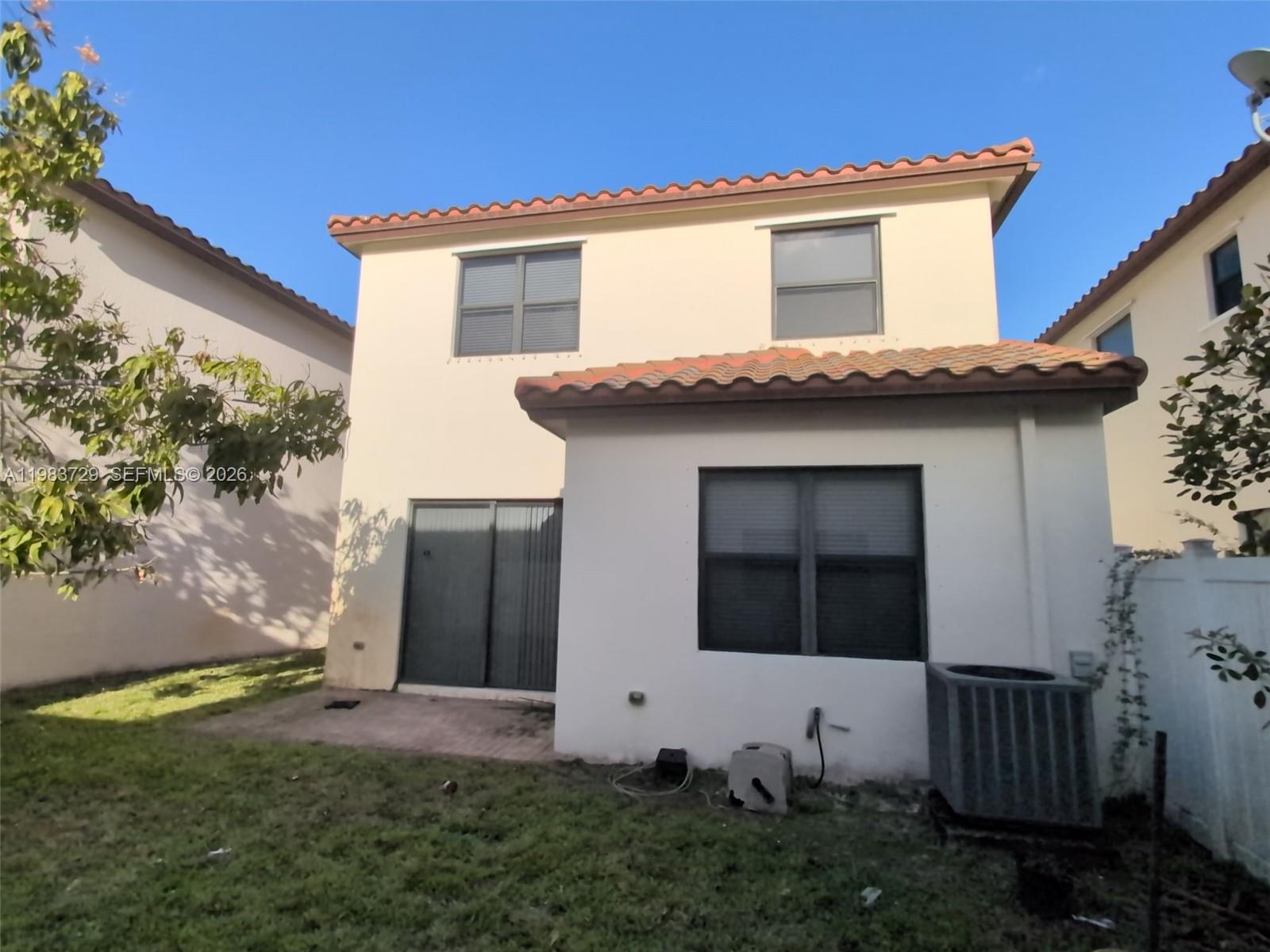 3578 Southwest 91st Way Miramar, FL 33025 - Photo 2 of 2 a white house with a small yard and a large window