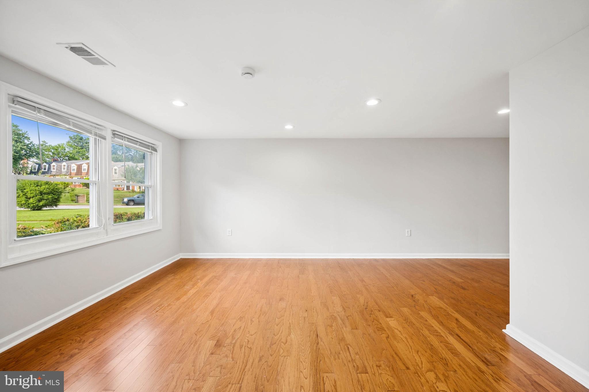 7227 Sindall Road Baltimore, MD 21234 - Photo 10 of 62 a view of an empty room with wooden floor and a window