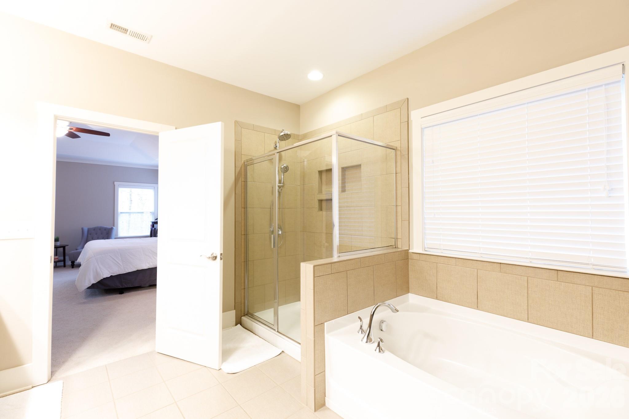 2172 Bluebell Way Tega Cay, SC 29708 - Photo 22 of 40 a en suite bathroom with a tub shower and bedroom view