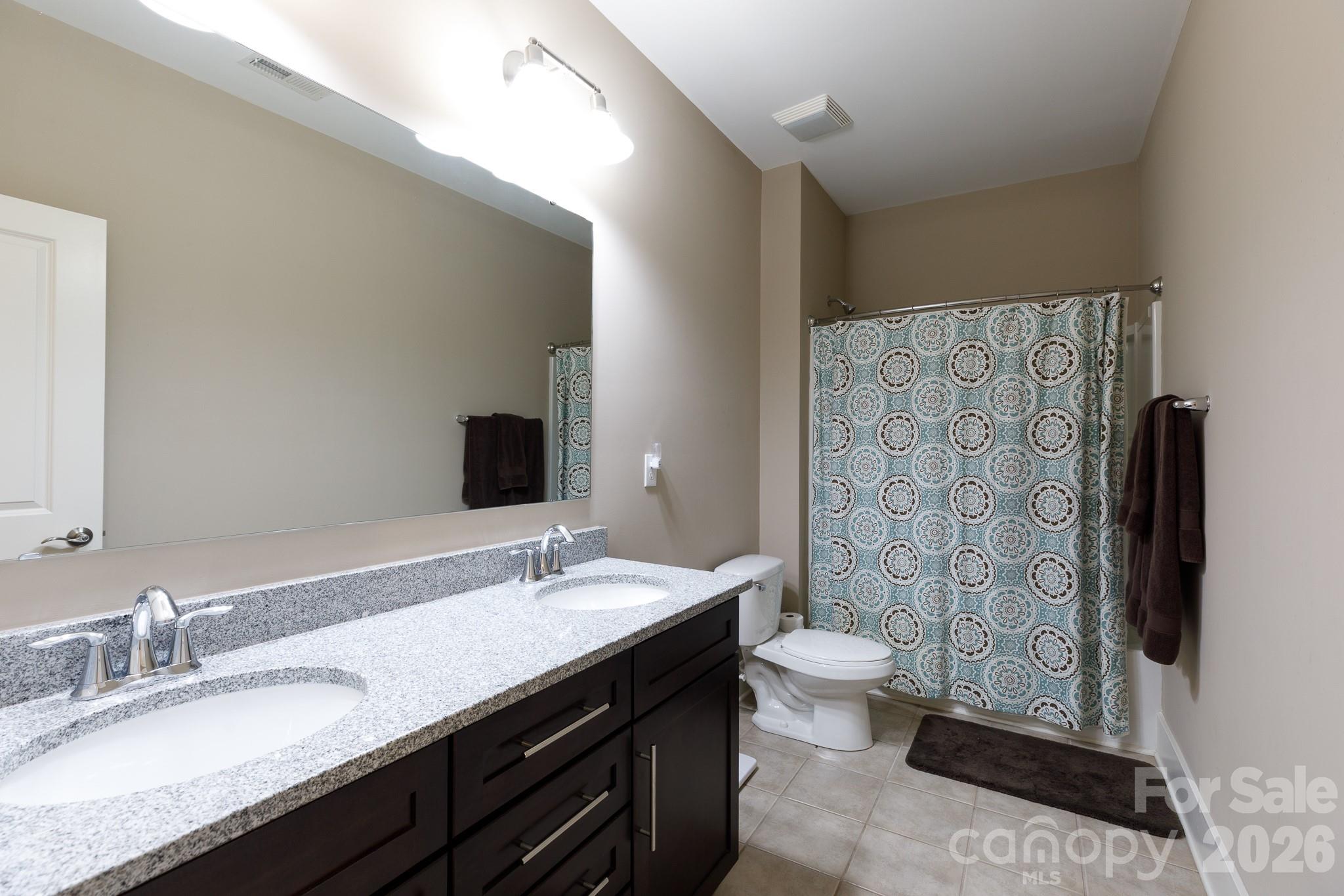 2172 Bluebell Way Tega Cay, SC 29708 - Photo 31 of 40 a bathroom with a double vanity sink toilet and shower