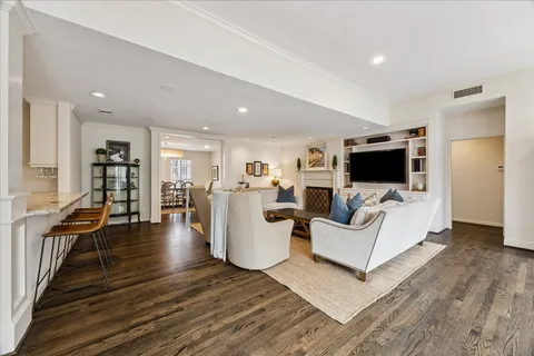 a large kitchen with stainless steel appliances granite countertop a stove a sink a dining table and chair with wooden floor