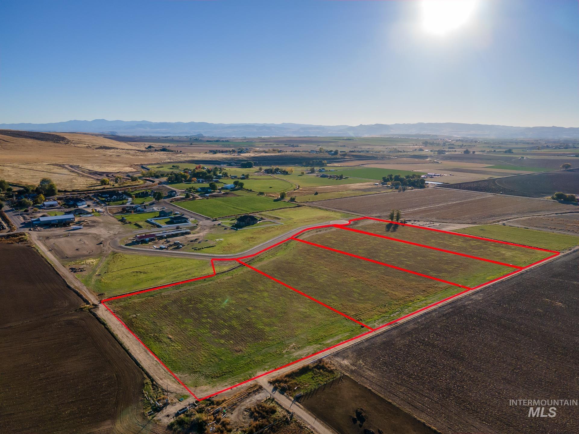 4188 West Mockingjay Kuna, ID 83634 - Photo 4 of 32 Aerial view of sparsely populated area featuring property boundaries highlighted, a mountain backdrop, and large plots for crops