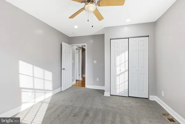 an empty room with chandelier fan
