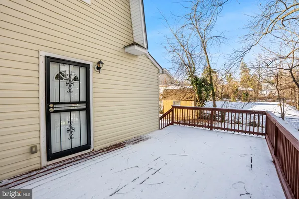 a backyard of a house with wooden fence and large trees