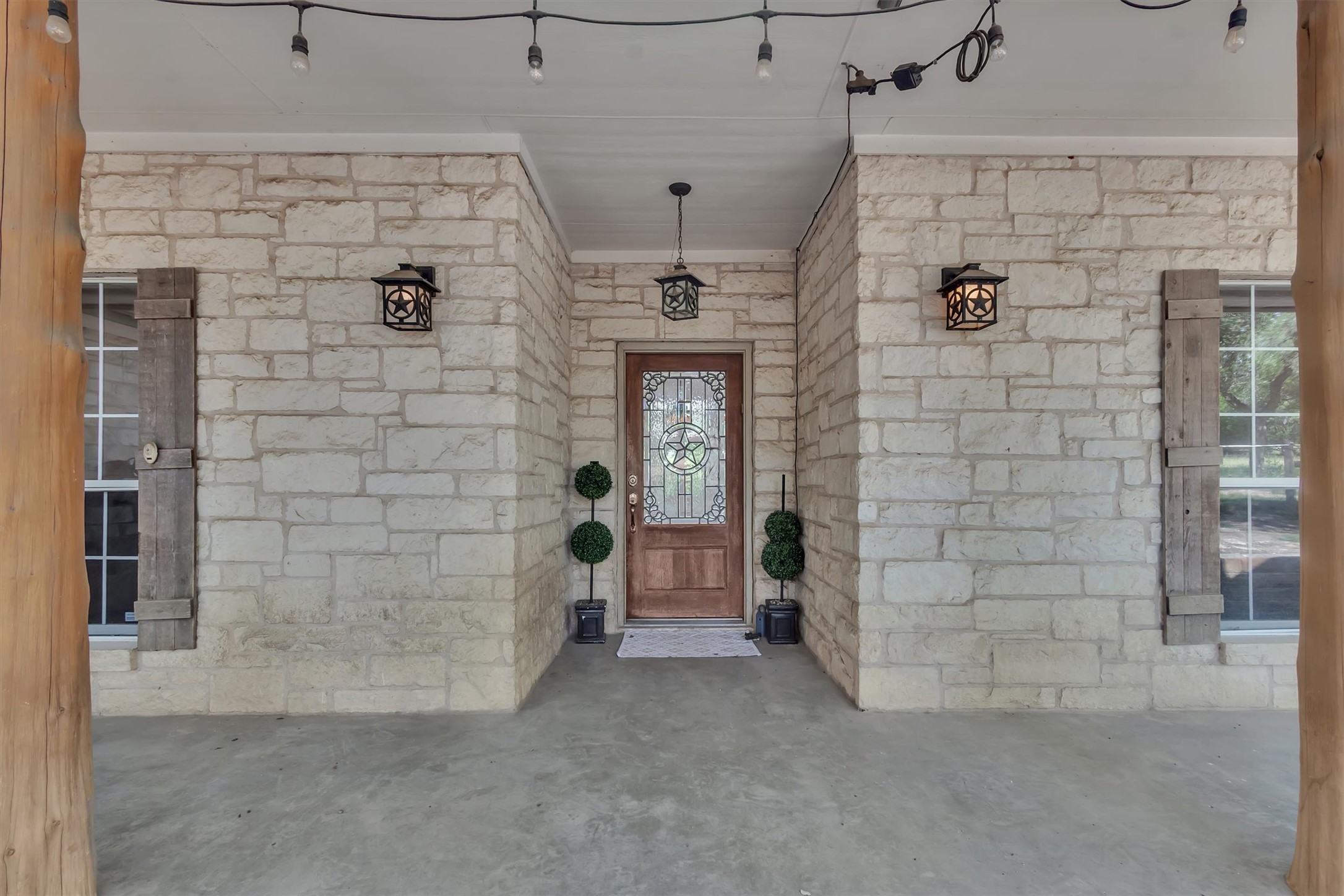 1120 Meadow Ridge Drive Austin, TX 78737 - Photo 5 of 40 A charming entry features rustic wooden shutters and classic stone masonry.