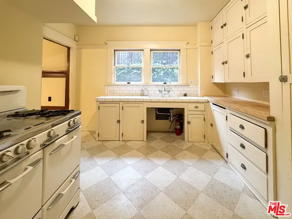 a kitchen with granite countertop a stove sink and cabinets