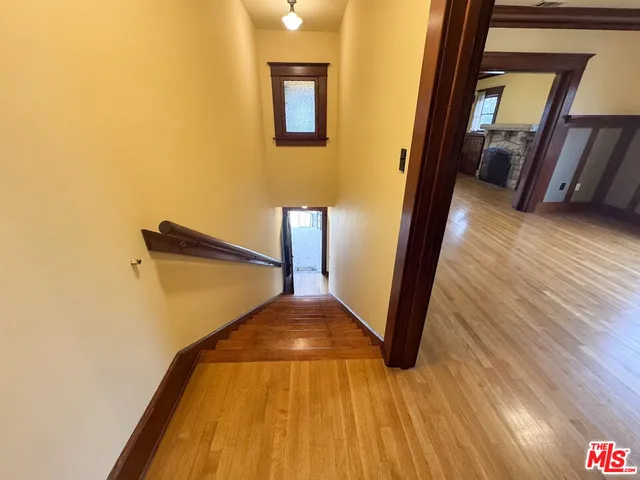 a view of a hallway with wooden floor and staircase