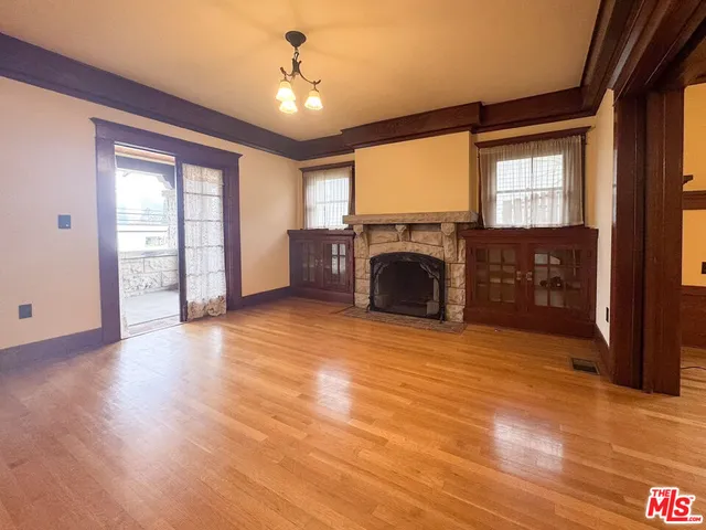 a view of empty room with a fireplace and wooden floor